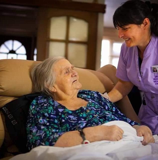 Carer supporting a lady in bed at home